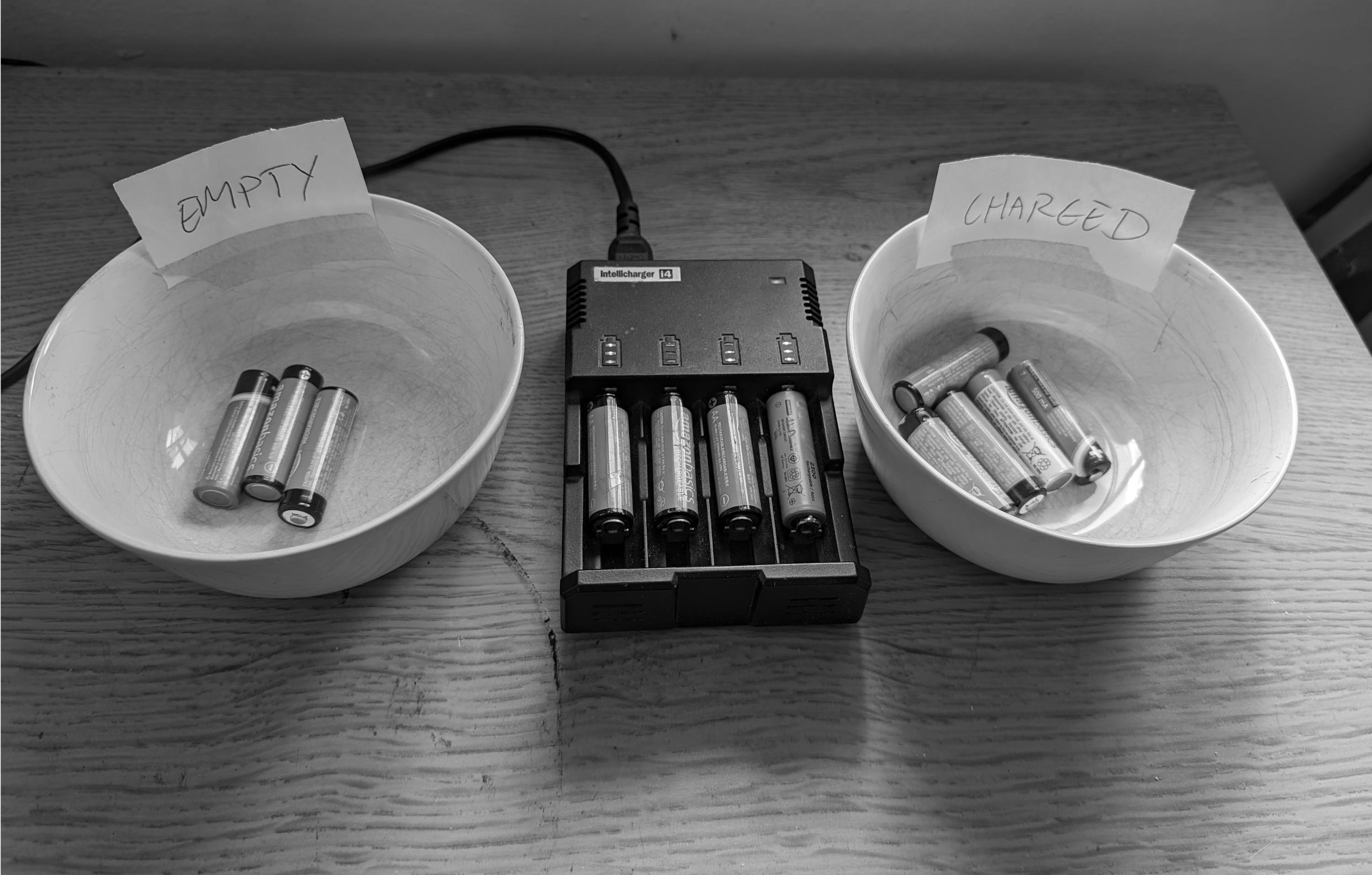 Bowls of loose batteries next to a conventional charger